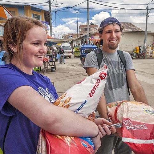 在秘鲁的一次服务旅行中，两个学生拿着面粉.